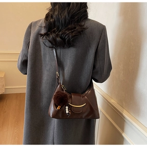 Brown vintage hobo bag details with gold moon metal piece and plush ball pendant