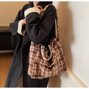 Close-up of a large plaid tote bag with thick woolen fabric texture for autumn and winter