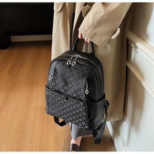 Detail of black backpack with pebble leather and checkerboard pattern on front pocket
