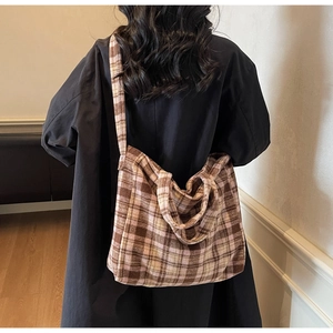 Detail of a large checkered tote bag showing thick wool texture and warm brown tones
