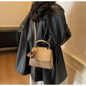 Rear view of a khaki patchwork crossbody square bag styled in a minimalist interior