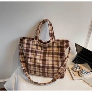 Detail of soft winter plaid tote bag featuring textured fabric and dual carrying straps