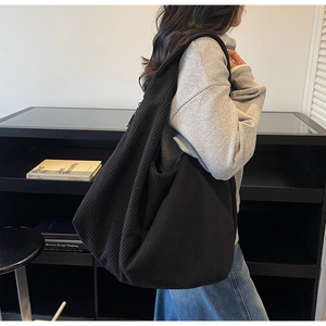 Détail d'un grand sac hobo en velours côtelé noir montrant sa texture douce et sa grande taille