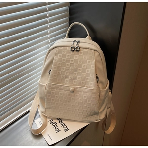 Detail of cream-white checkerboard embossed faux leather backpack with front pocket and straps