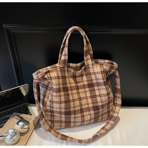 Close-up of brown and beige plaid plush tote bag with long strap and soft fuzzy texture