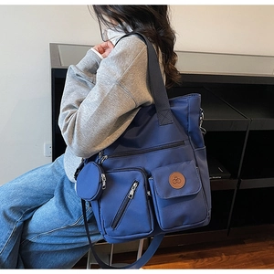 Détail du grand sac cabas en nylon bleu foncé avec poches zippées et petit porte-monnaie
