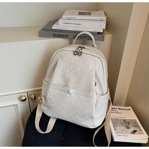 Detail of white faux leather backpack featuring embossed checkerboard texture and dual zippers