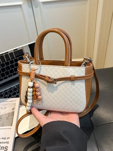 Chic checkered crossbody bag in beige and brown leather with a decorative beaded charm