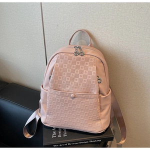 Detailed view of pink lychee grain PU leather backpack with checkered embossed pattern