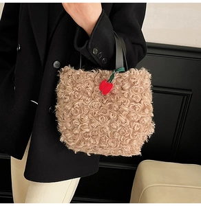 Detail of light brown faux fur tote bag with plush lamb wool texture and cherry charm