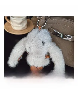Close-up of a plush bunny charm in light grey faux fur with brown leather accents