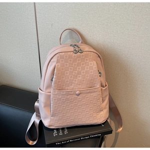 Detail of pink pebbled leather backpack with square quilted texture and silver ring zippers