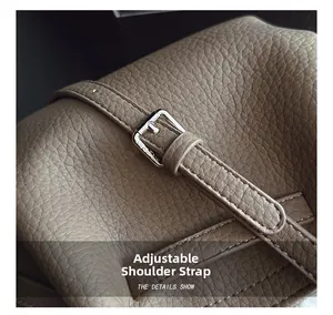 Detail of adjustable strap with silver metal buckle on pebbled leather bucket bag