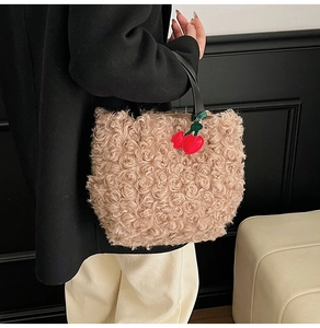 Detail of light camel faux fur bucket bag with rose textures and cherry charm
