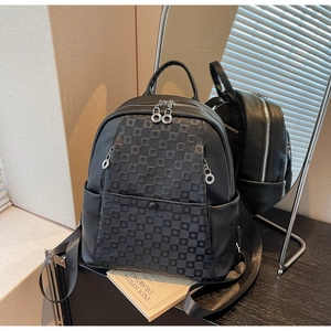 Detail of black pebbled leather backpack with grey checkerboard pattern and silver hardware
