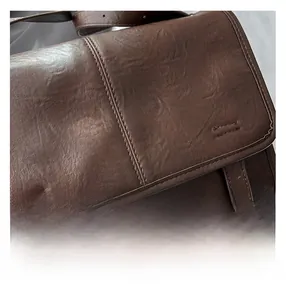 Close-up of retro brown tote bag showing lychee grain leather and reinforced double stitching