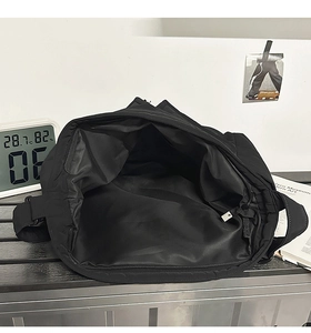 Detail view of the spacious inner compartment and smooth lining of the black tote bag