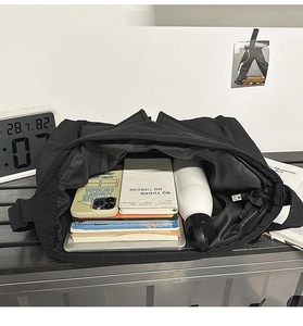 Internal view of black nylon tote bag showing high capacity for laptop and water bottle