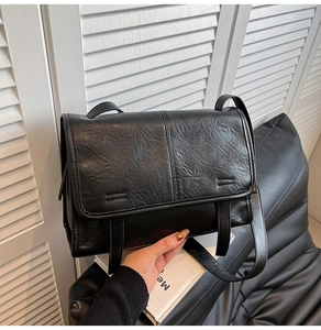 Close-up of black retro tote bag featuring vintage wrinkled faux leather texture and flap