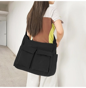 Side view of black nylon messenger bag with multiple pockets and large storage capacity
