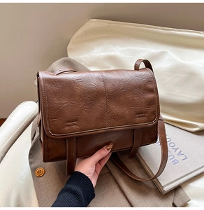 Detail of vintage brown leather tote bag showing textured flap and strap design
