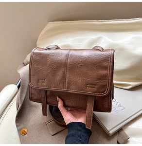 Detailed close-up of dark brown vintage leather tote with natural textures and stitching
