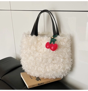 Close-up of beige plush bucket bag with curly faux fur and red cherry pendant detail