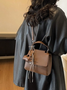 Brown litchi leather square shoulder bag with adjustable strap and bohemian charm