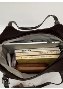 Vista macro del interior de un gran bolso tote de cuero marrón con varios compartimentos