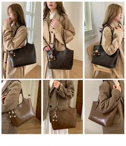 Detalle de un bolso tote grande vintage en cuero PU marrón con un lindo colgante de peluche