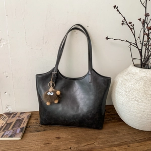 Bolso tote retro de cuero PU negro con colgante de monstruo de peluche marrón