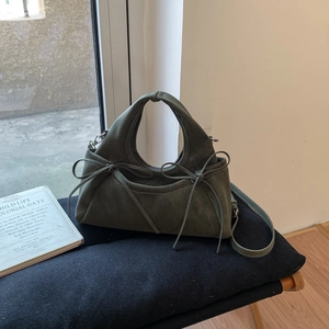 Détails du sac à main en daim vert foncé avec nœuds décoratifs et bandoulière amovible