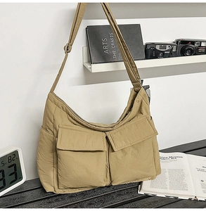 Detail view of khaki large capacity nylon tote with double front pockets and wide strap