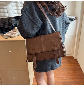 Detail of vintage brown tote bag with leather grain texture and classic buckle straps