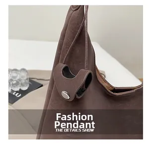 Detail of brown textured leather bag with silver metal snap button and buckle on the side