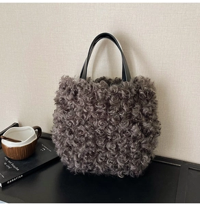 Close-up of curly faux fur texture and leather handle on a brown bucket tote bag