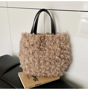 Close-up of plush teddy fleece texture and contrasting black leather handle on tote bag