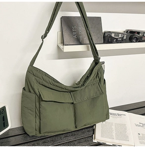 Detail of army green nylon tote bag featuring large utility pockets and wide strap