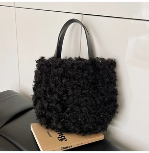 Detailed close-up of a black faux lamb fur tote bag on a retro book and leather bench