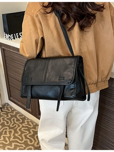 Retro black wrinkled leather tote bag with flap and decorative straps shown on model