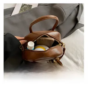 Top view of brown leather pillow bag interior showing storage space and gold hardware