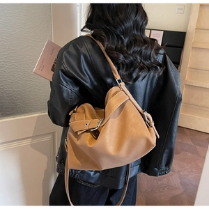Détail du sac cabas vintage en cuir marron avec boucle en métal et bandoulière large