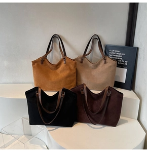 Vue détaillée de quatre sacs cabas en daim en caramel et beige sur un présentoir