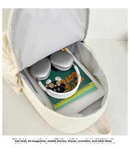 Spacious interior of cream quilted backpack holding A4 magazines and headphones