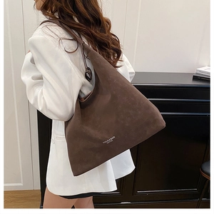 Nahaufnahme der braunen Hobo-Tasche aus Wildlederimitat mit Markenlogo-Aufdruck