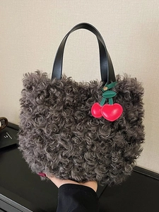 Grey faux fur teddy bucket bag with black leather handle and red cherry pendant