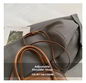 Close-up of adjustable leather strap with gold metal buckle on a brown vintage pillow bag