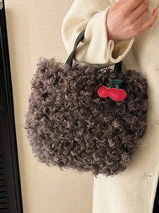 Grey curly faux fur bucket bag with red cherry charm accessory for autumn and winter