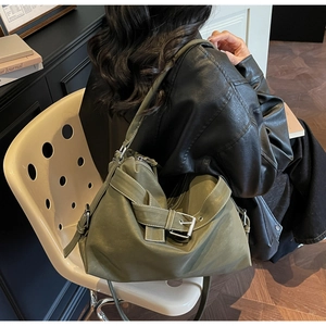 Detail view of olive green tote bag with wide strap, metal buckle and contrast stitching