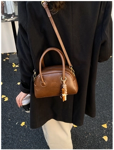 Brown vintage Boston bag with beads charm shown in a cozy autumn street setting
